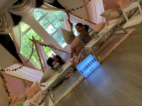 A girl sitting on a couch in a room with a teepee.