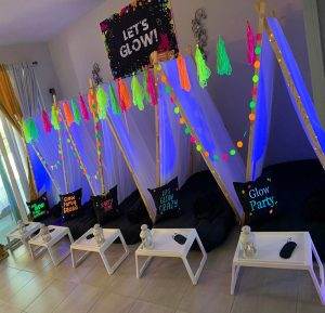 Black lights lighting up teepees and glow in the dark decorations.