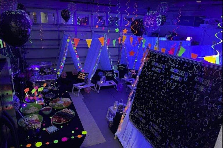 Glow in the dark decorations and food surrounding a teepee party thrown by Slumberr.