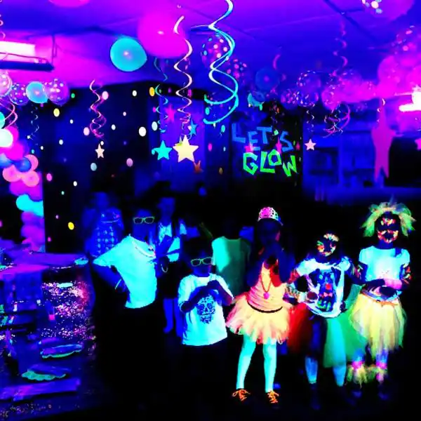 A party in a room with neon lights and balloons.