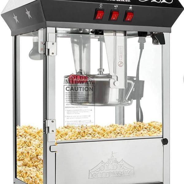 Commercial popcorn machine with a stainless steel base and clear glass panels, filled with freshly popped popcorn, perfect for an outdoor movie night, labeled "Olde Midway.