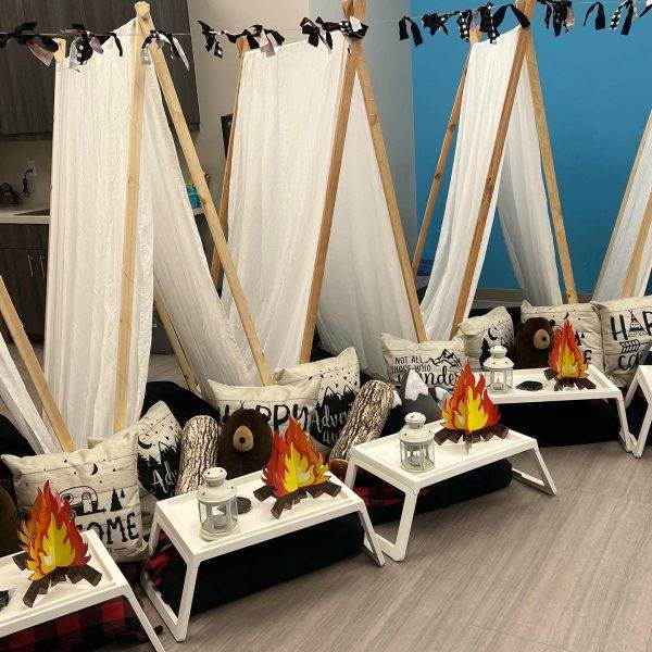 A teepee tent is set up in a room, transforming it into a cozy party space.