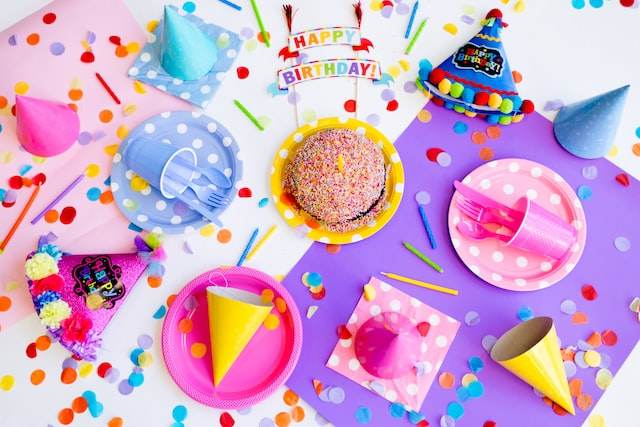 A vibrant birthday party filled with plates, cups, and confetti.