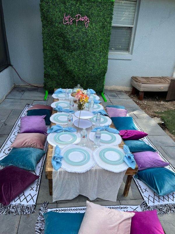 boho luxury picnic on grey tiles in front of green photo prop