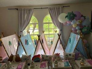 Party Themes 6 5 teepees set up inside a living room with squishmellows and party trays.