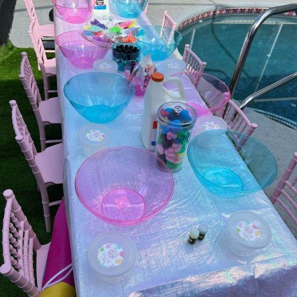 A table set up with blue and pink bowls and plates perfect for a glamping experience.