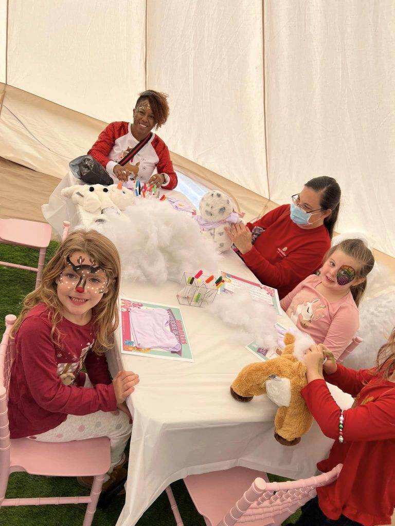 A group of children sitting at a Lakeland table in a Bell Tent.