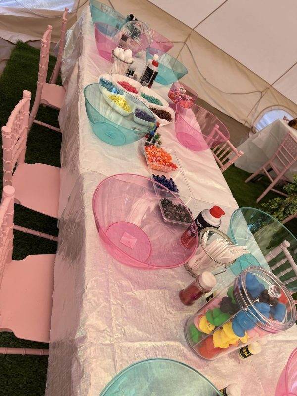 A party tent set up with pink and blue bowls for a glamping themed event.
