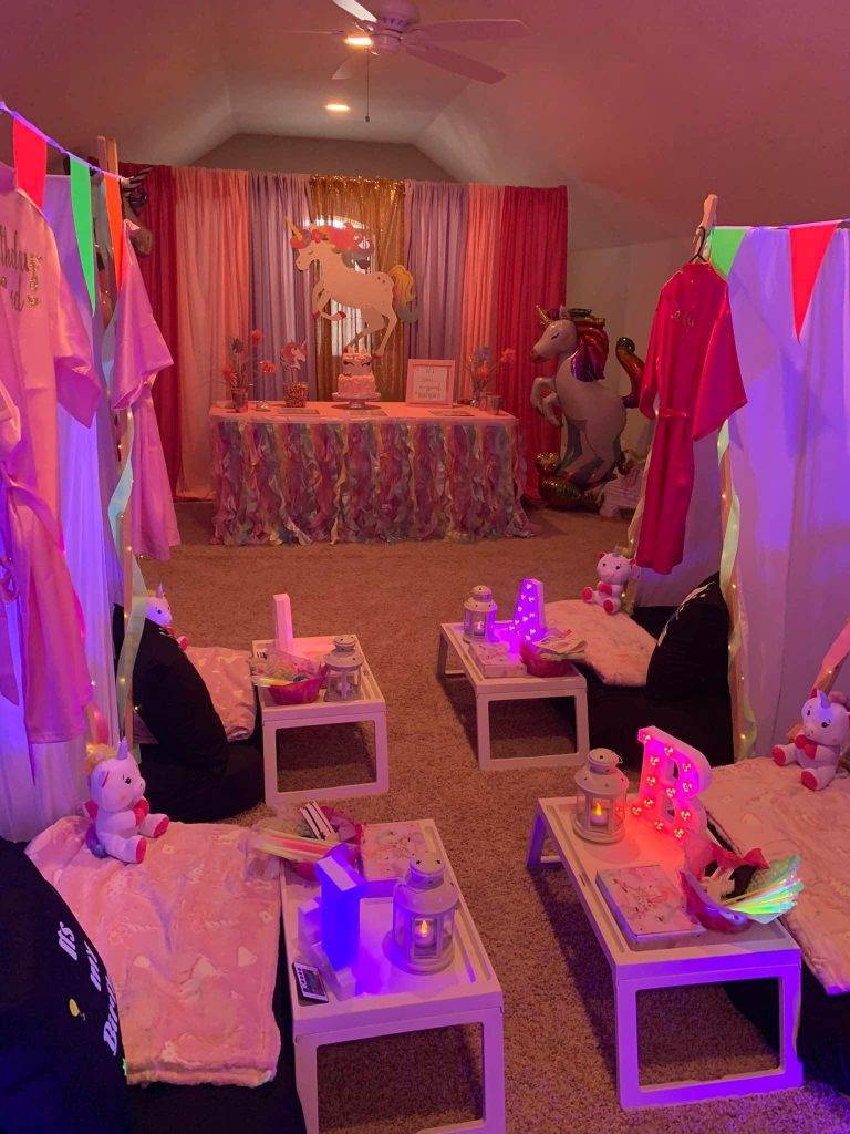 A glamping-themed room decorated for a birthday party with pink and purple decorations.