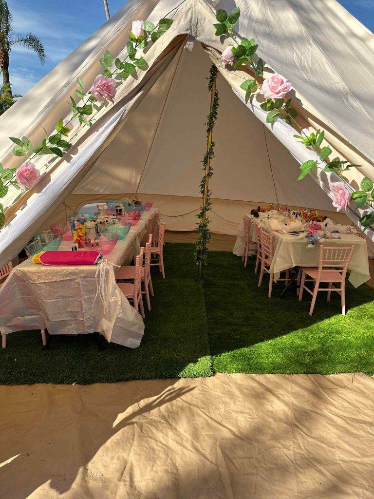 A pink and white tent set up for a party in Lakeland, featuring a table and chairs inside.