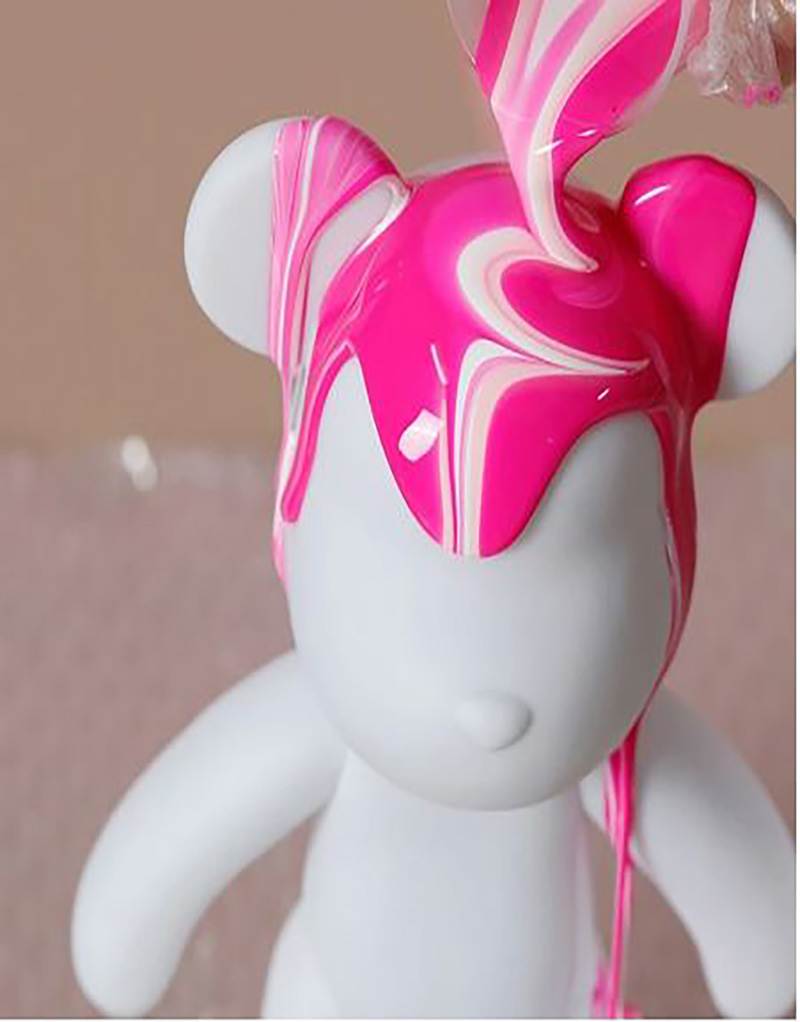 A teddy bear with pink and white swirls on its head, perfect for a party.