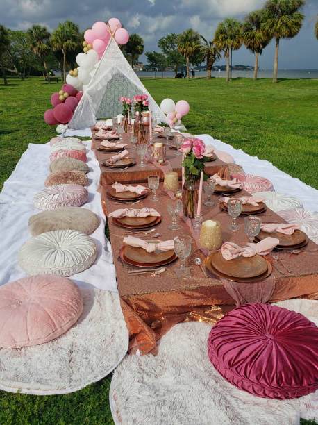 A party table set up with pink pillows and balloons.