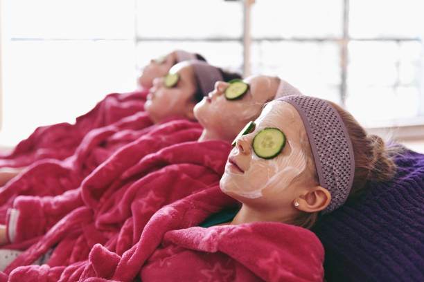 A group of girls in pink robes with cucumber masks on their faces enjoy a fun and relaxing glamping weekend at a scenic Lakeland destination.
