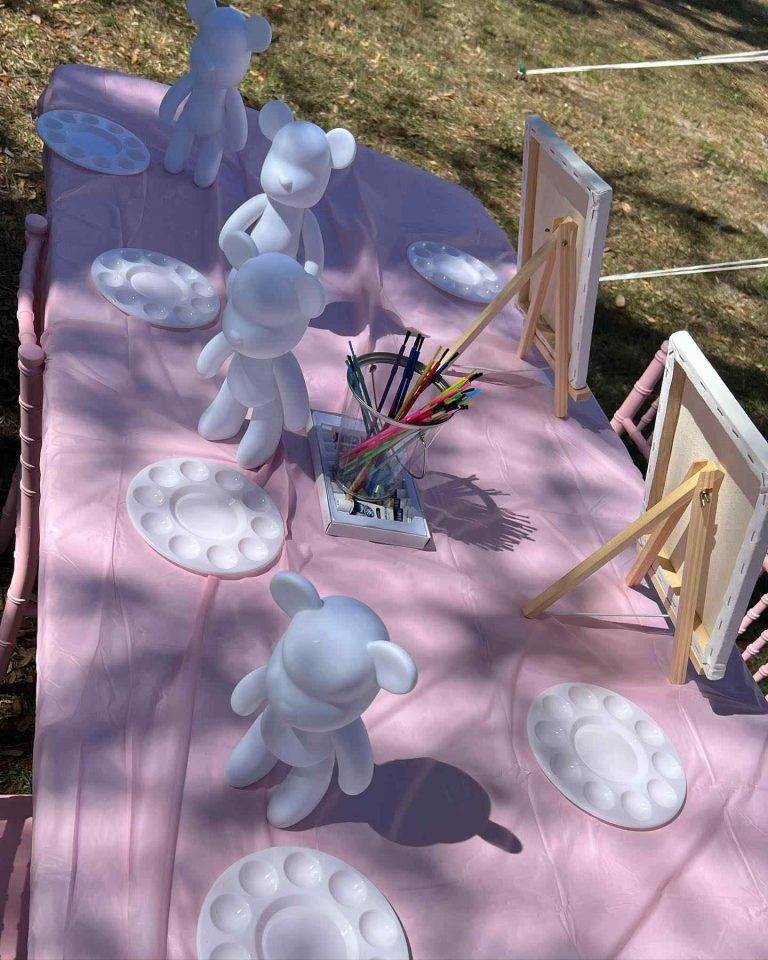 A pink tablecloth adorned with adorable white teddy bears, perfect for adding a touch of whimsy to your glamping setup.