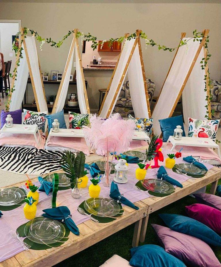 A teepee party set up in a glamping style, complete with a table adorned with slime decorations.