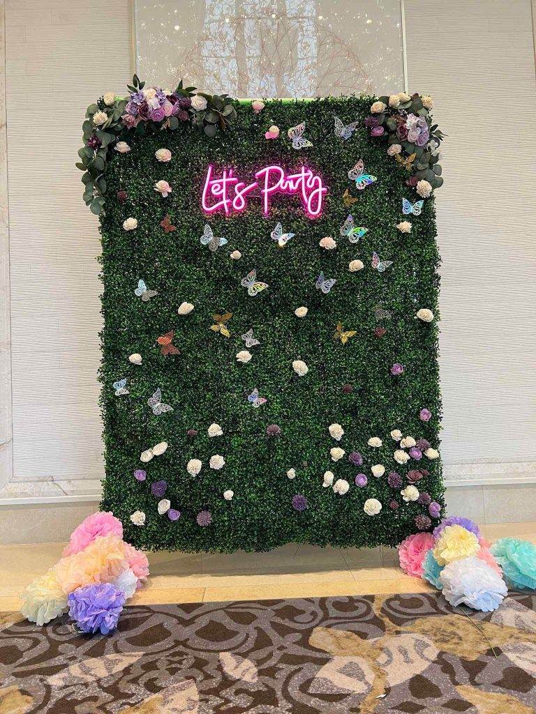 Ivy backdrop that you can stand in front of with a LED Sign that says Lets Party