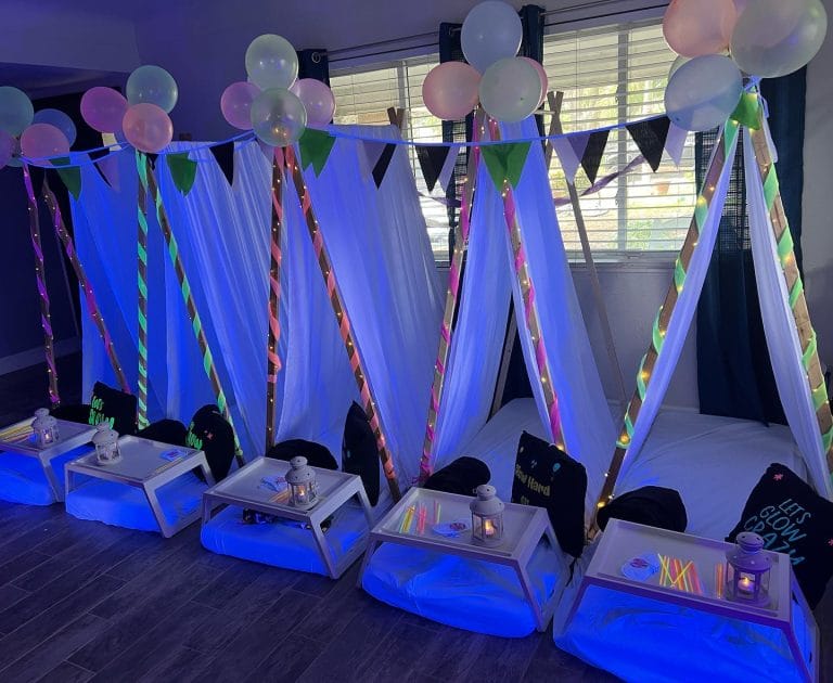 Glow in the dark theme teepee tents sitting inside a house with balloons and decorations