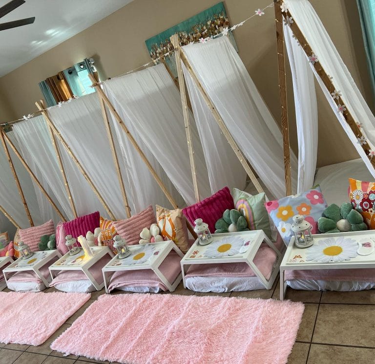 indoor teepee party using wooden teepees and comfortable memory foam mattresses inside and food trays in front.