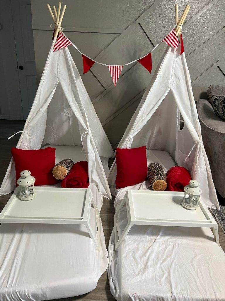 Two teepee beds decorated with red and white for a festive party ambiance.