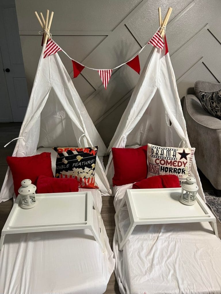 Two white teepee beds with red and white decorations in a Lakeland-themed party.