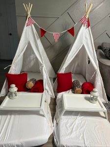 Two Teepee beds with red and white decorations.