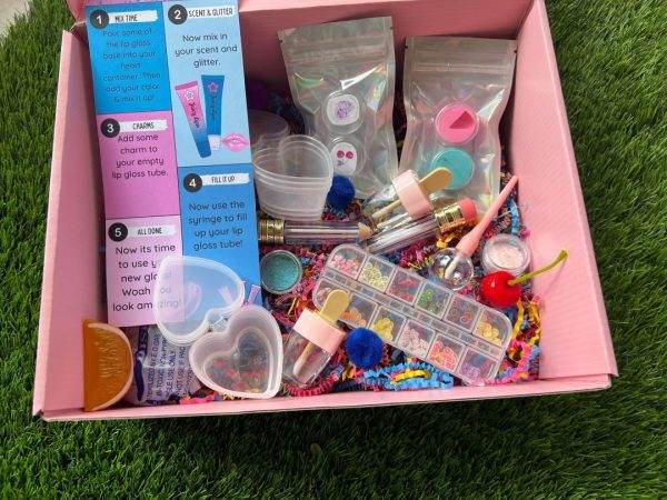 A DIY Lip Gloss Party Box filled with party cosmetics and other items.