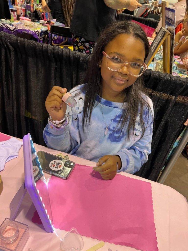 A girl at a Lakeland party table making Slime crafts.