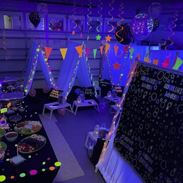 A party room decorated with neon lights and balloons, perfect for a lively celebration.