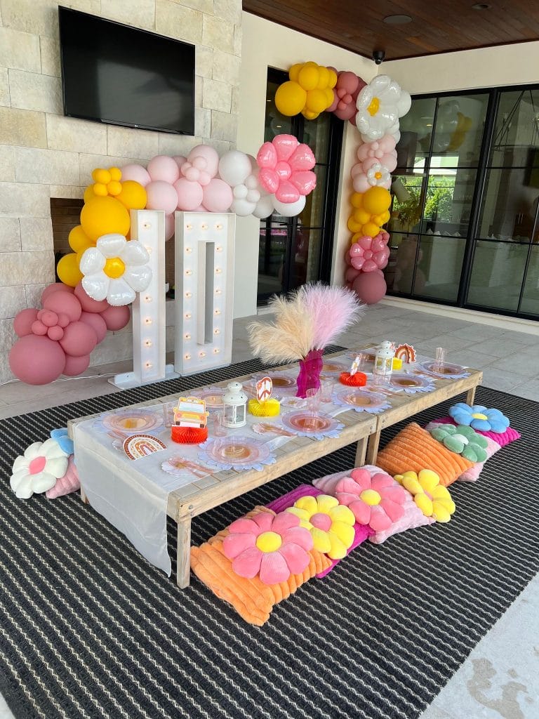 A festive birthday party set up with balloons and flowers.