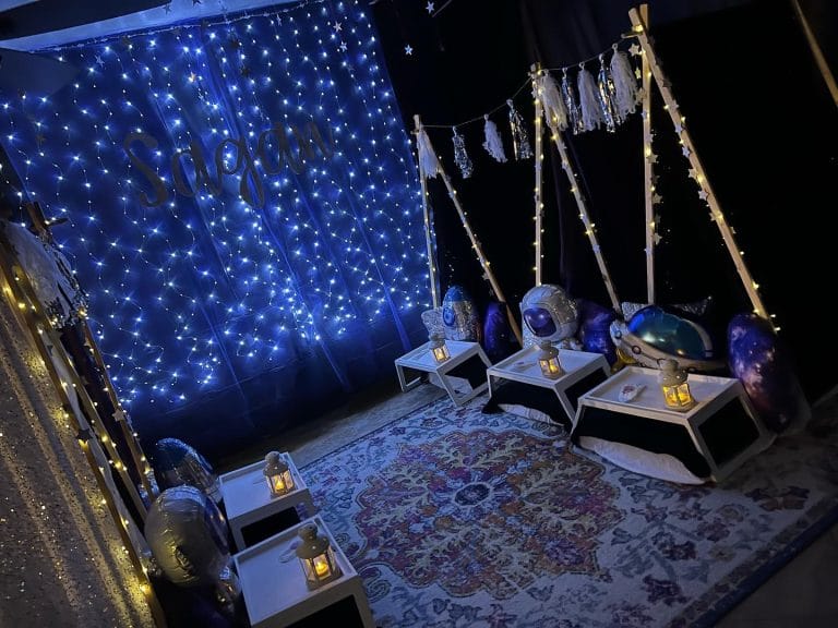 A party room decorated with blue lights and candles for a glamping experience.