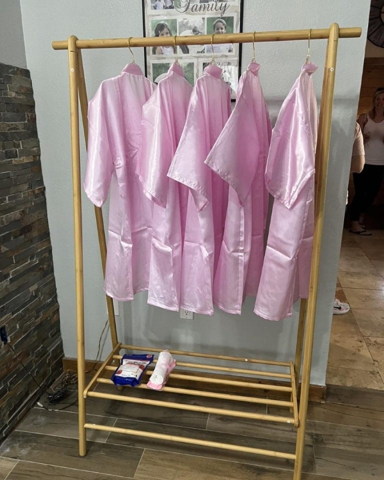 Lakeland-inspired pink robes hanging on a wooden rack.