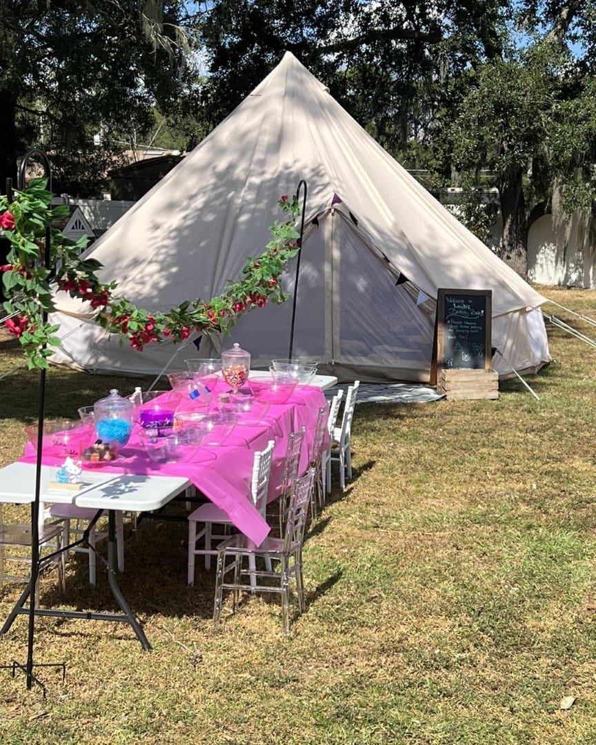 A pink teepee with a table and chairs.