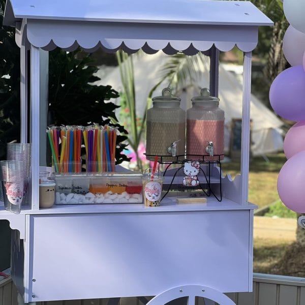 An ice cream cart with balloons and glittering party decorations.
