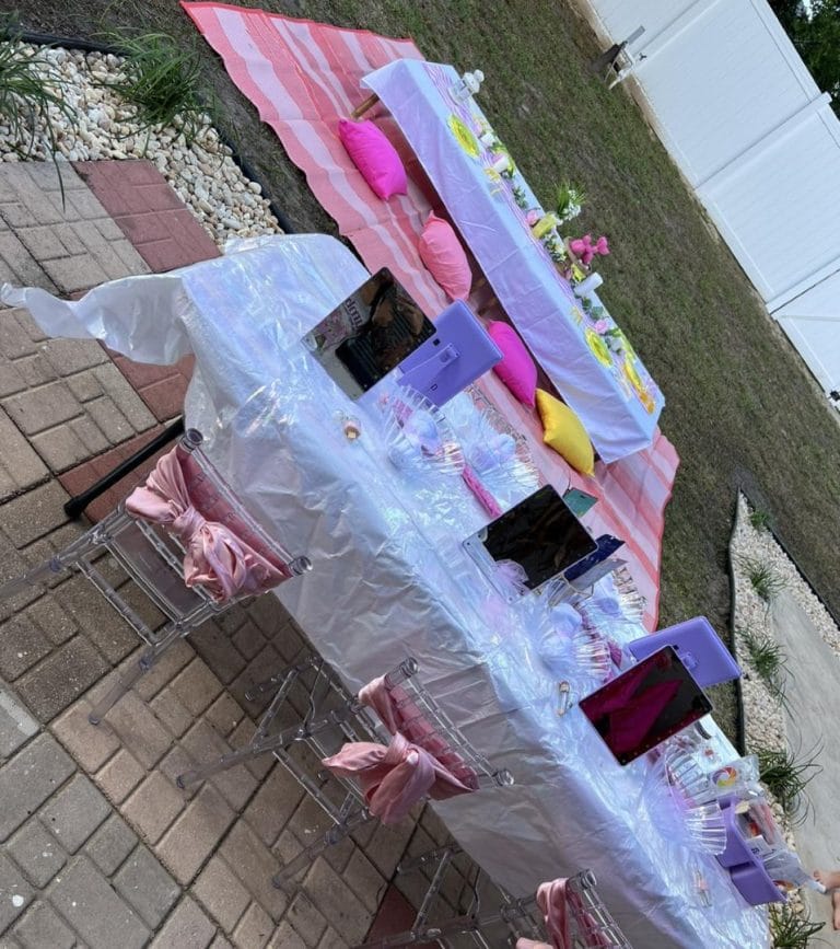 A party table set up for a girl's birthday party, featuring slime decorations.