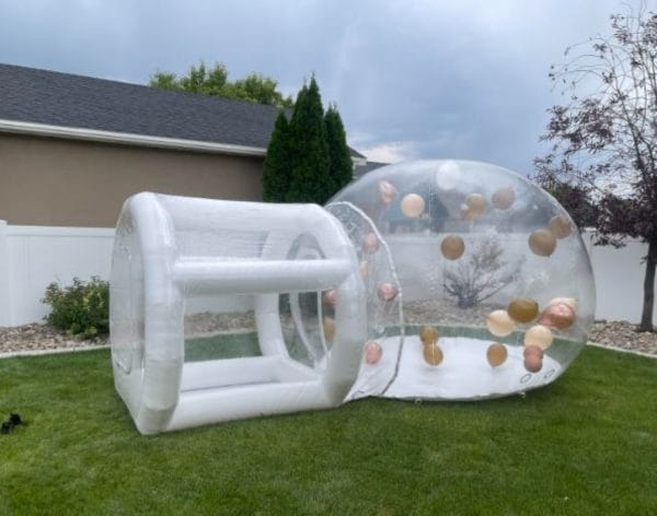 An enchanting bubble balloon house rental set up in a yard.