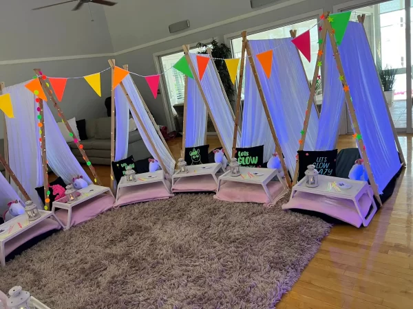 A group of teepee tents set up in a living room for a Unicorn Party Theme.