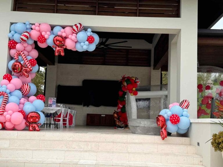 A balloon arch decorated with pink and blue balloons for a glamping event.