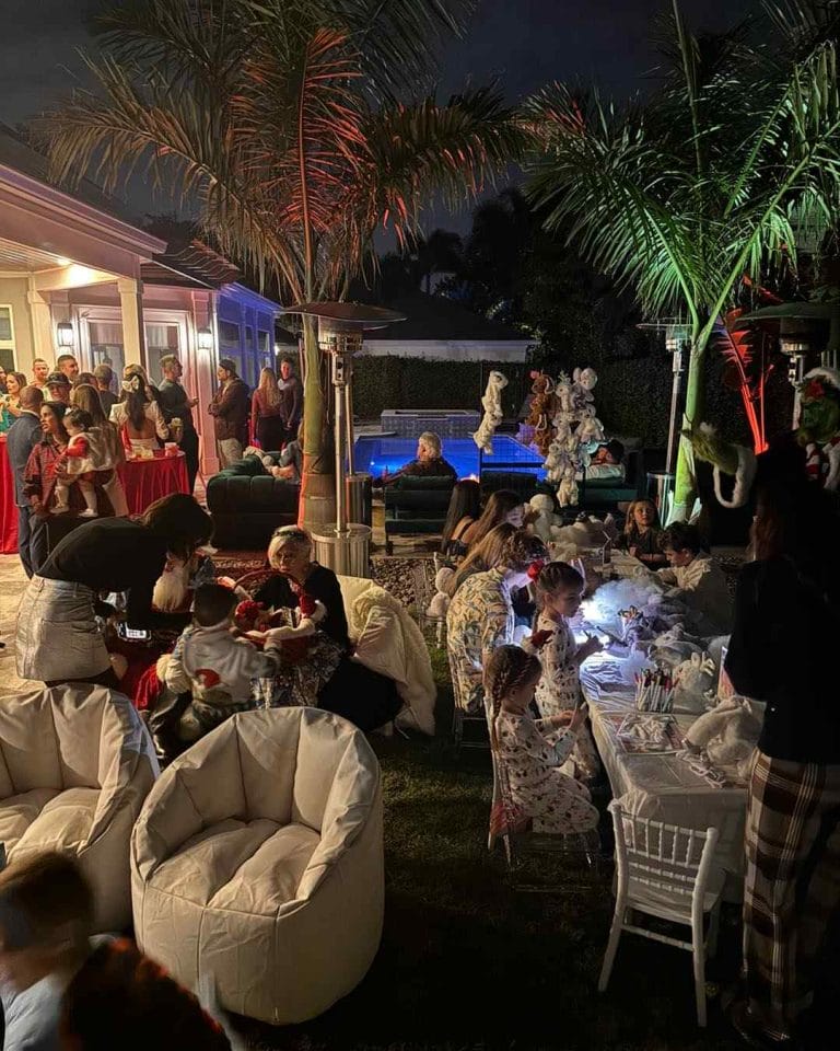 Outdoor christmas party in florida with outdoor seating, build a bear table and a beautiful pool in the background.