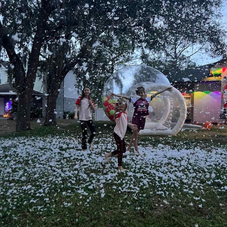 Bubble dome and snow machine with children and adults playing in the front yard