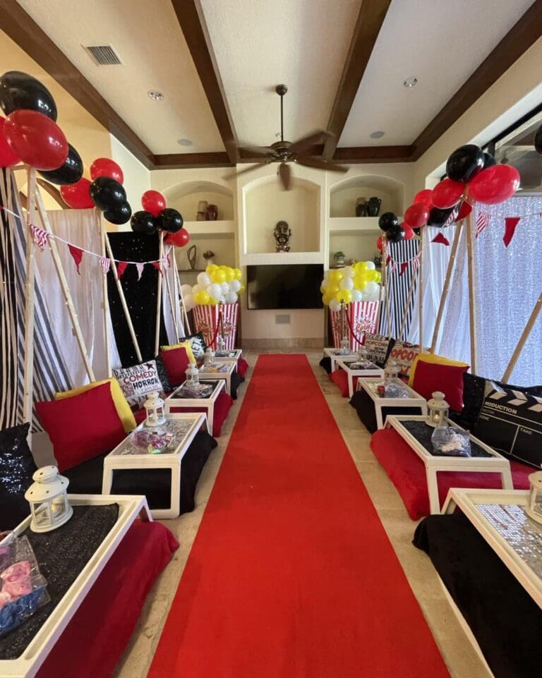 Step into a Hollywood-inspired movie-themed party room, lavishly decorated to transport you straight to the glitz and glamour of the silver screen. A plush red carpet welcomes guests in true celebrity style, setting the scene for an unforgettable cinematic experience. Eye-catching black and red balloons float above, adding pops of drama and excitement throughout the space. Cozy up with an array of decorative movie-themed pillows featuring iconic film reels, clapperboards, and popcorn motifs—perfect for creating that ultimate blockbuster ambiance. Ideal for any film fanatic or those looking to host an Oscar-worthy celebration!